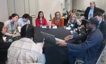 a group of adults sitting around a table talking